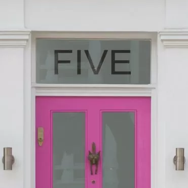 House number sticker on a pink front door